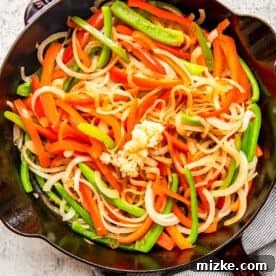 bell peppers, onions, and garlic in a cast iron skillet