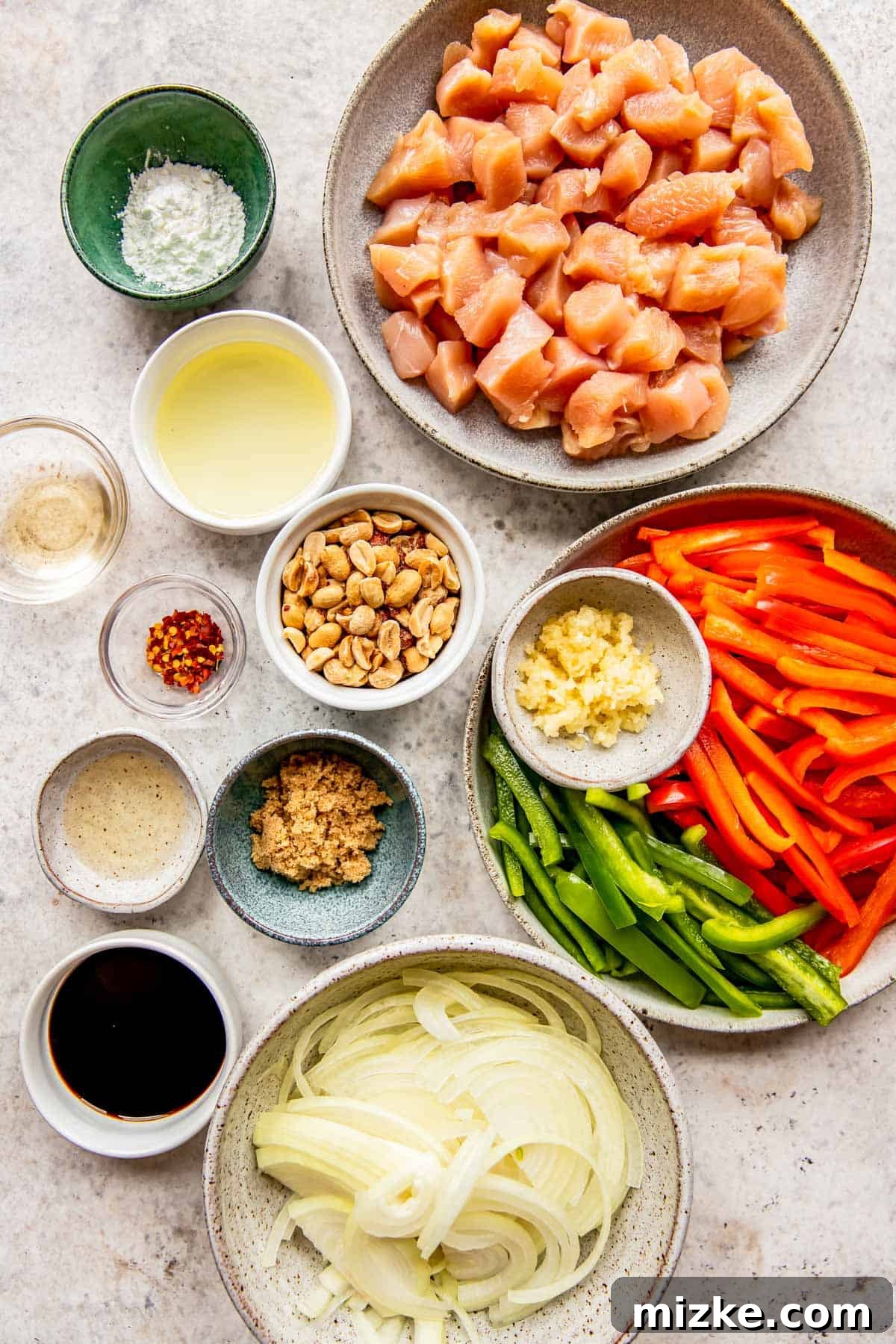 Spicy Szechuan Peanut Chicken 3 A selection of fresh ingredients laid out for Kung Pao Chicken, including chicken, vegetables, and sauce components.