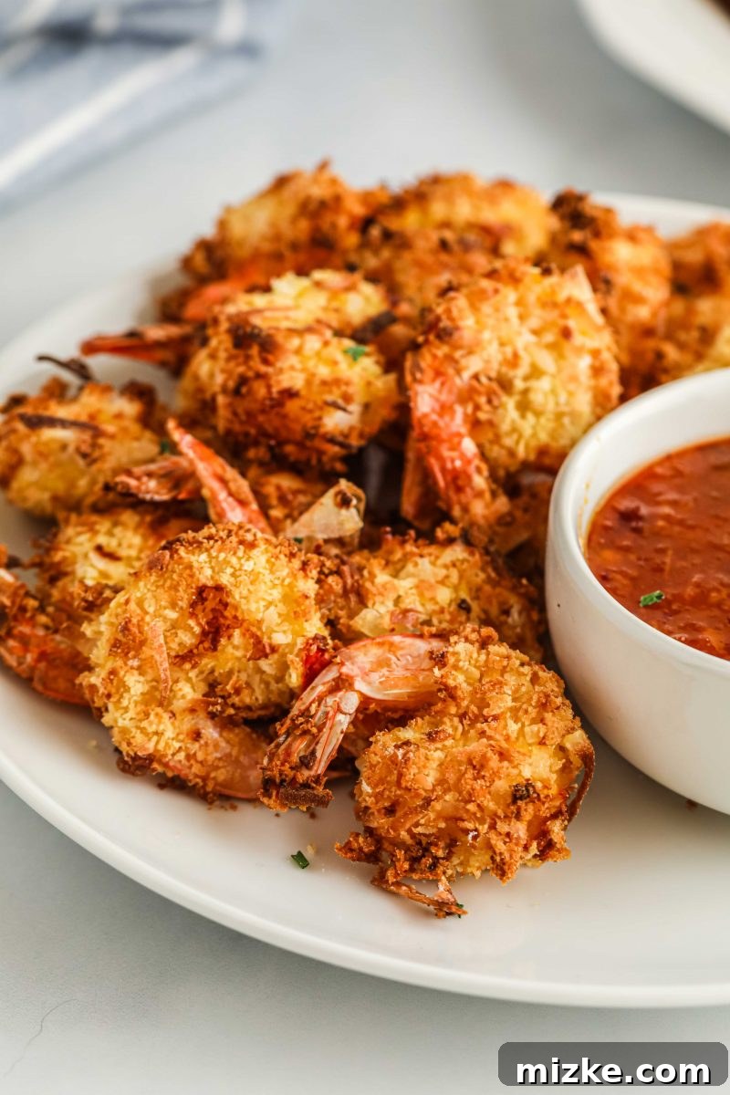 Crispy Air Fryer Coconut Shrimp 3 Close-up of perfectly cooked air fryer coconut shrimp with a golden, textured coating.