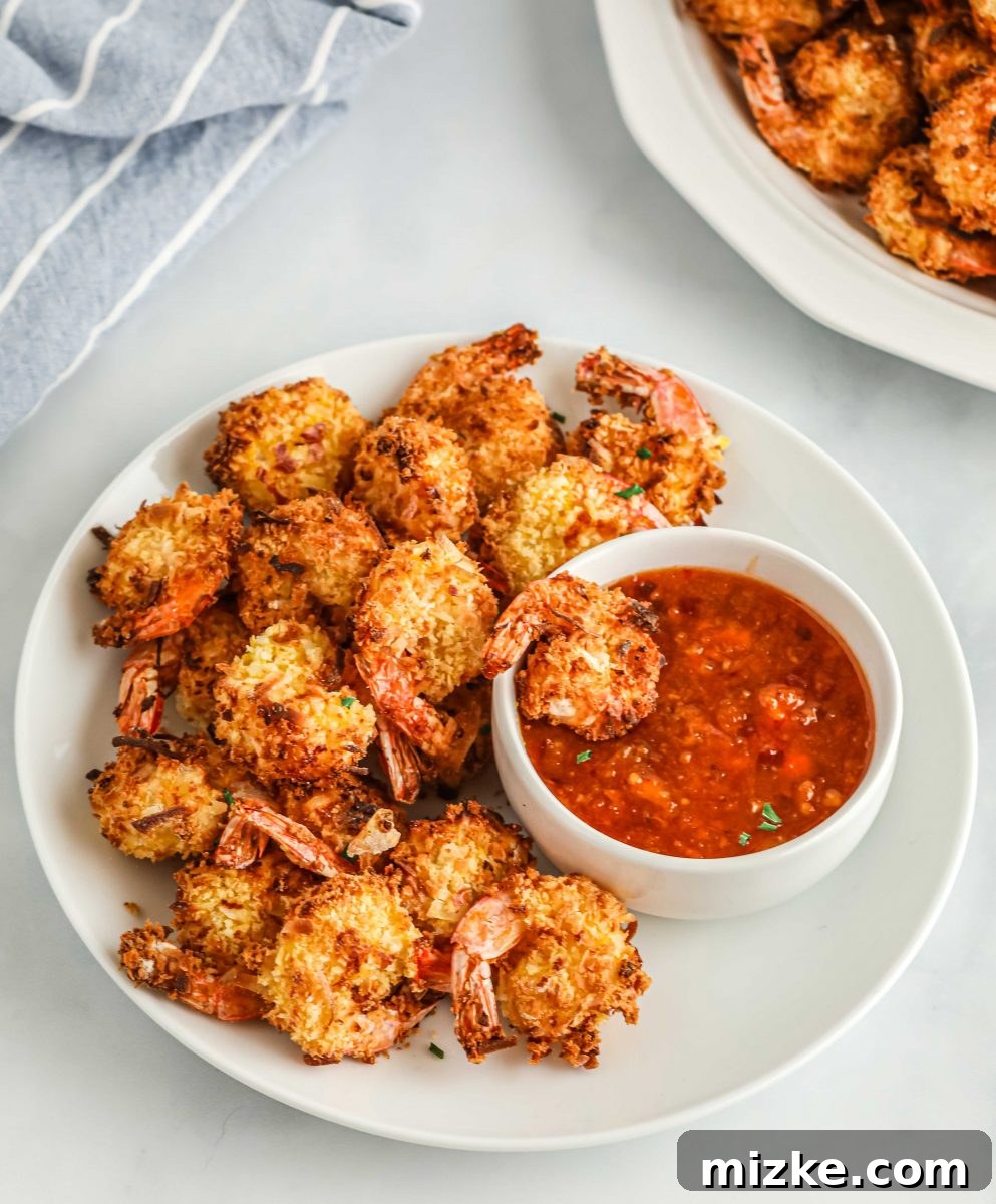 Crispy Air Fryer Coconut Shrimp 5 Bowls of ingredients: flour, beaten eggs, and a mix of panko breadcrumbs and shredded coconut, set up for dredging shrimp.