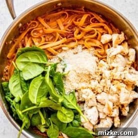 Sun-Kissed Skillet Chicken Pasta 21 Fresh spinach, Parmesan cheese, and cooked chicken added to the pasta in the stainless steel skillet