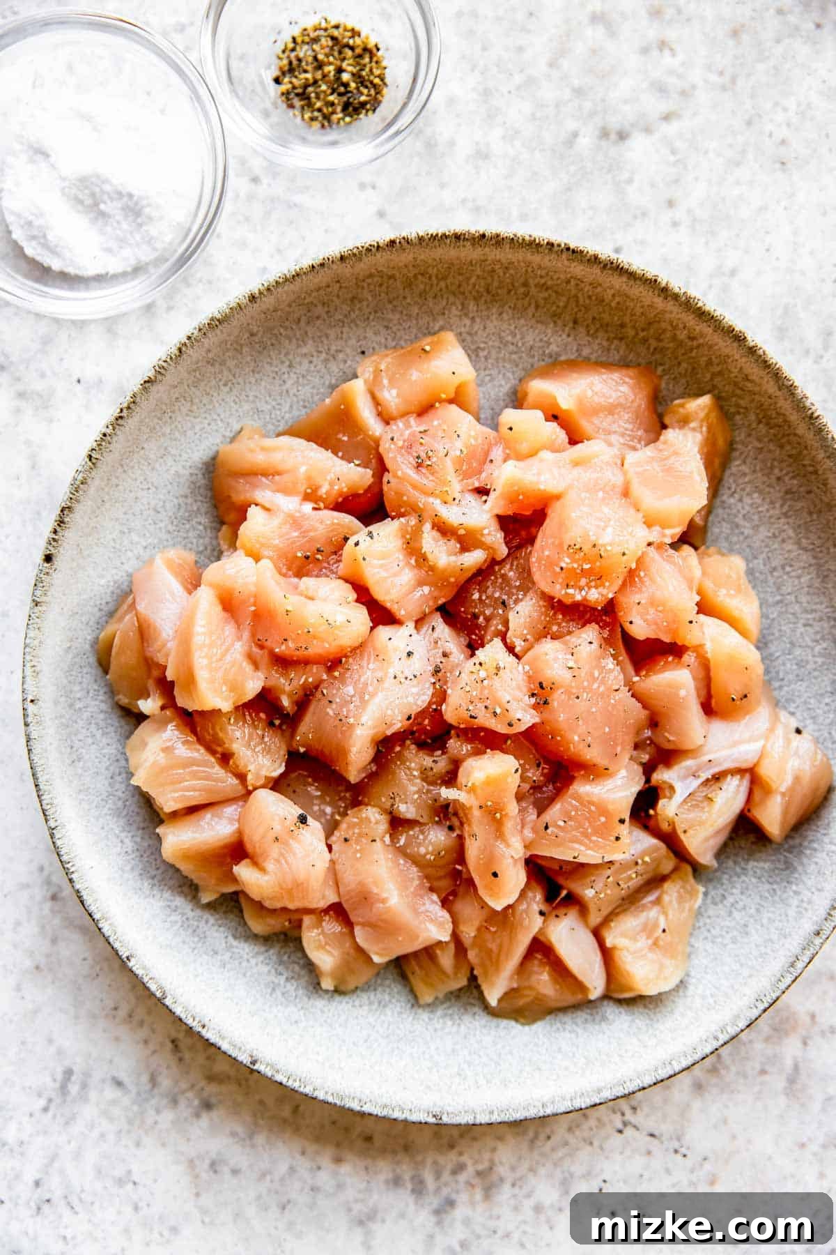 Sun-Kissed Skillet Chicken Pasta 4 Raw chicken breast pieces in a bowl, generously sprinkled with salt and freshly ground black pepper