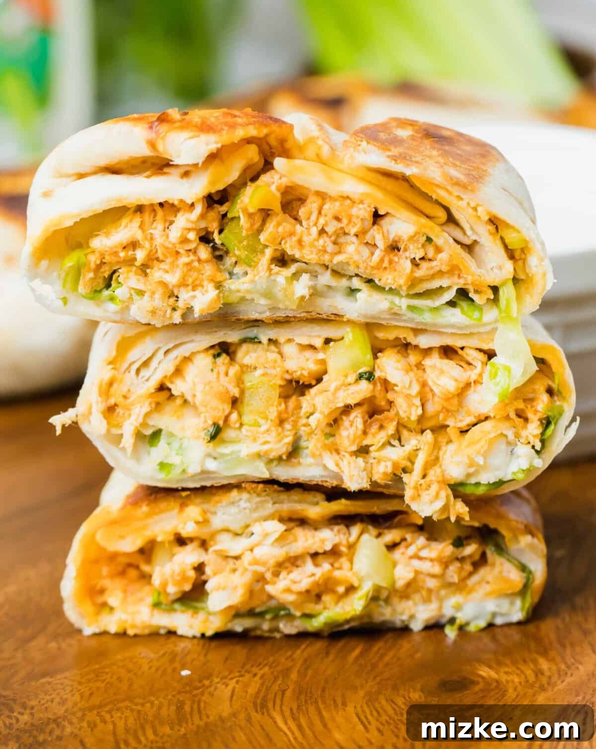 Three mini buffalo chicken crunchwraps have been cut in half and stacked in a little pile, revealing their delicious filling.