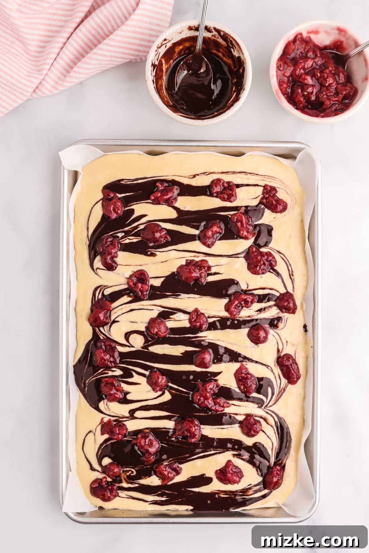 Chocolate Cherry Pancake Bake 7 Tart cherries dotted across the top of the pancake batter and chocolate sauce on the sheet pan