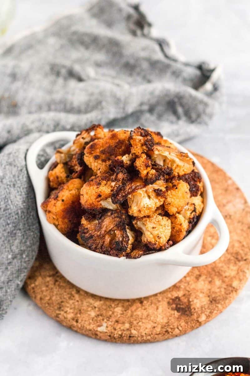 Mind-Blowing Roasted Cauliflower 4 Ingredients laid out for making roasted cauliflower, including cauliflower florets, smoked paprika, brown sugar, and various oils.