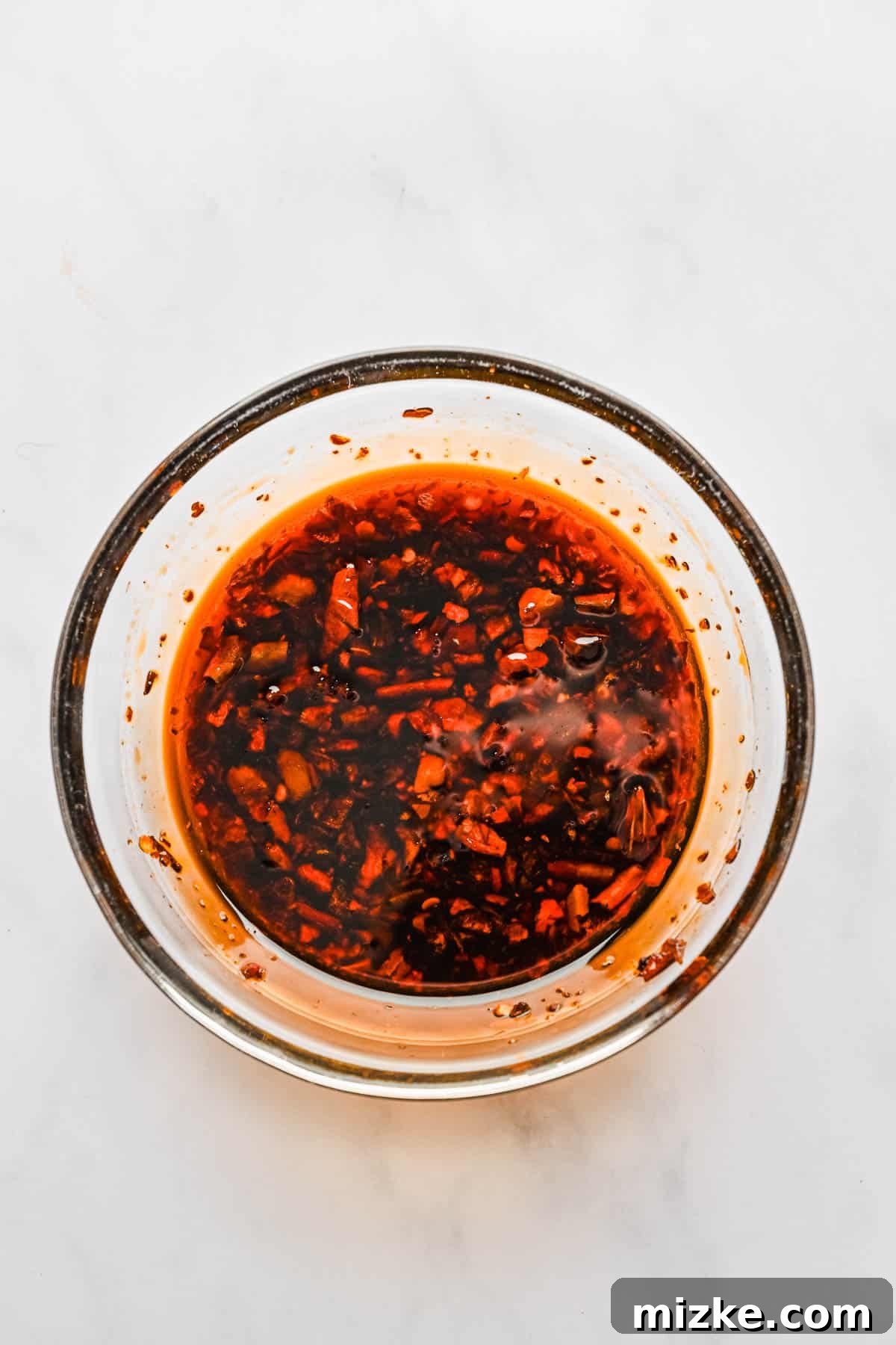 Crispy Tofu Stir-Fry 5 A rich, fiery red chili crunch sauce, the key ingredient for the lava sauce, glistens invitingly in a small glass bowl, ready to be mixed.