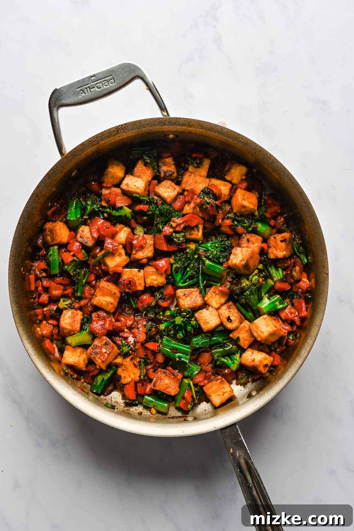 Crispy Tofu Stir-Fry 10 The spicy chili tofu stir fry, featuring tender vegetables and crispy tofu coated in a rich, glossy sauce, comes together perfectly in a large metal skillet.