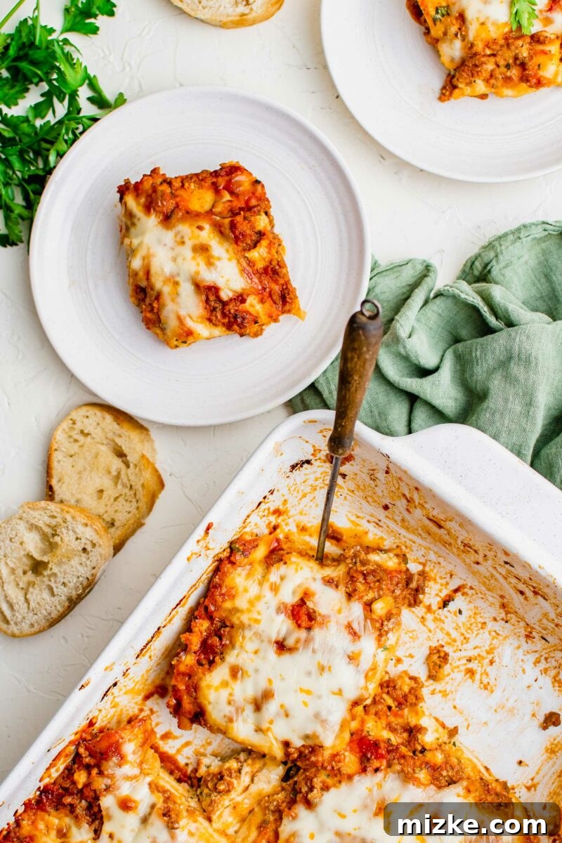 Ravioli Lasagna Bake 2 A white baking dish is full of cut lasagna squares, showcasing rich layers of pasta, sauce, and cheese.