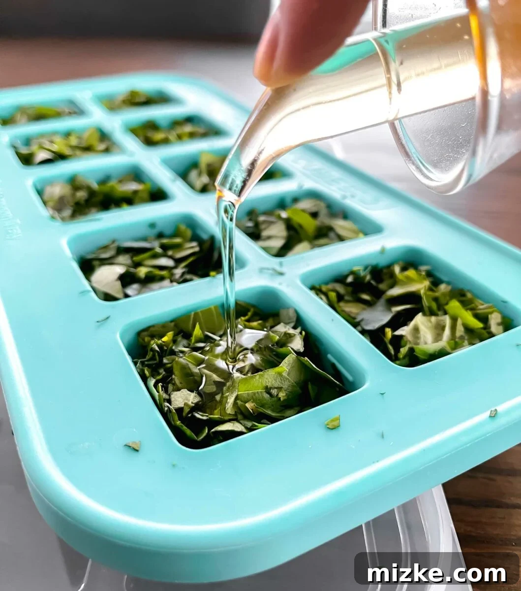 Capture Fresh Flavor: Freezing Herbs and Citrus 3 Various types of chopped herbs, including basil and parsley, in an ice cube tray with olive oil