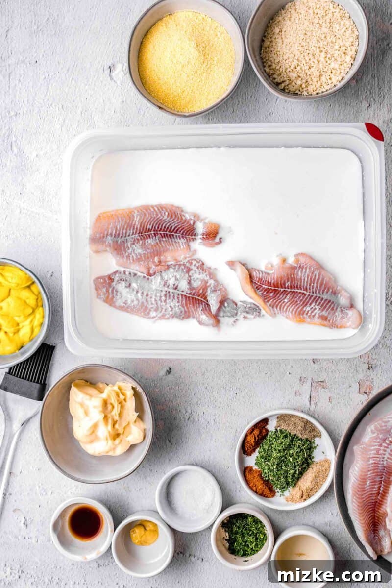 Crispy Golden Air Fryer Catfish 4 Catfish fillets soaking in a milk and lemon juice mixture in a shallow plastic container.