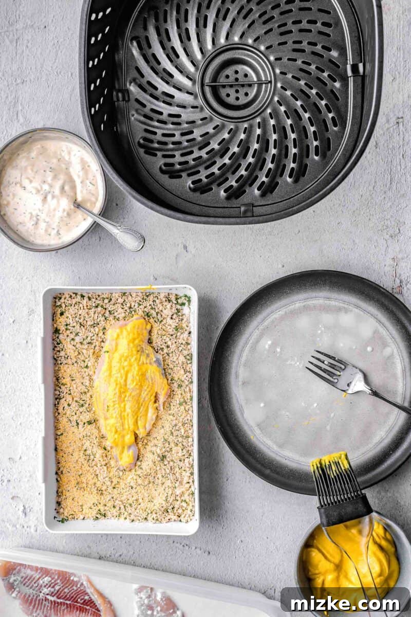 Crispy Golden Air Fryer Catfish 5 A piece of catfish being coated evenly with the breadcrumb and cornmeal mixture.