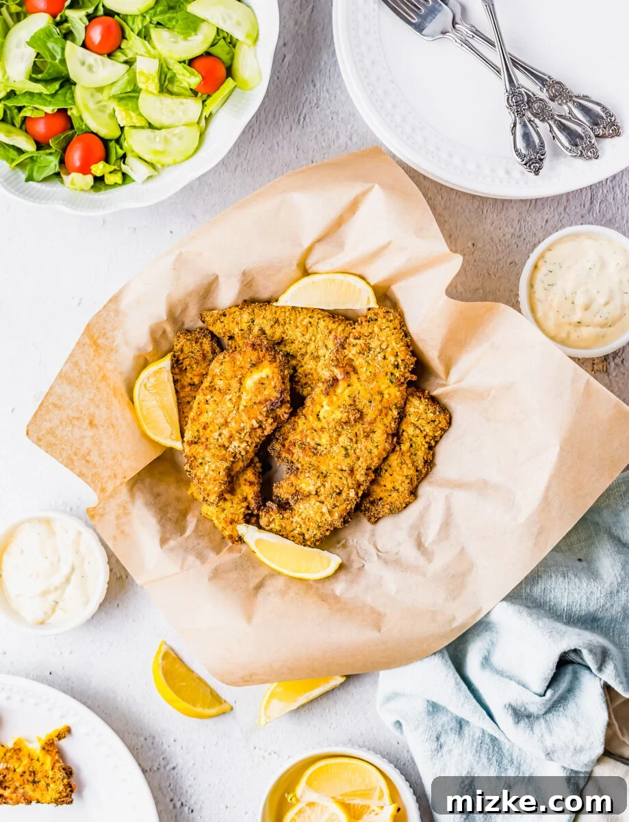 Crispy Golden Air Fryer Catfish 8 A basket of perfectly air-fried catfish fillets, served on brown parchment paper, awaiting enjoyment.
