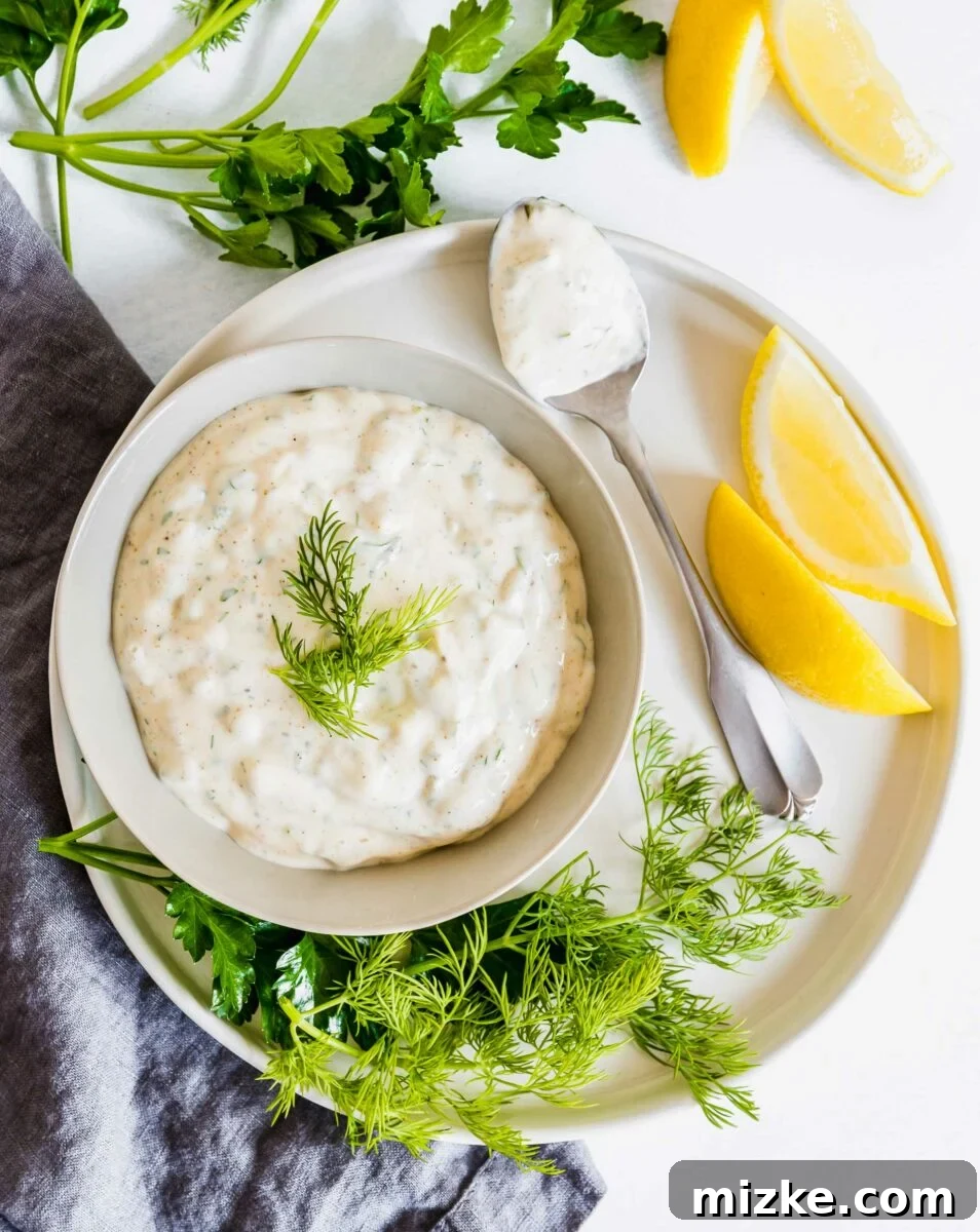 Fresh and Zesty Tartar From Scratch 2 A beautifully presented bowl of creamy homemade tartar sauce, garnished with fresh dill and lemon slices, ready to be served with seafood.