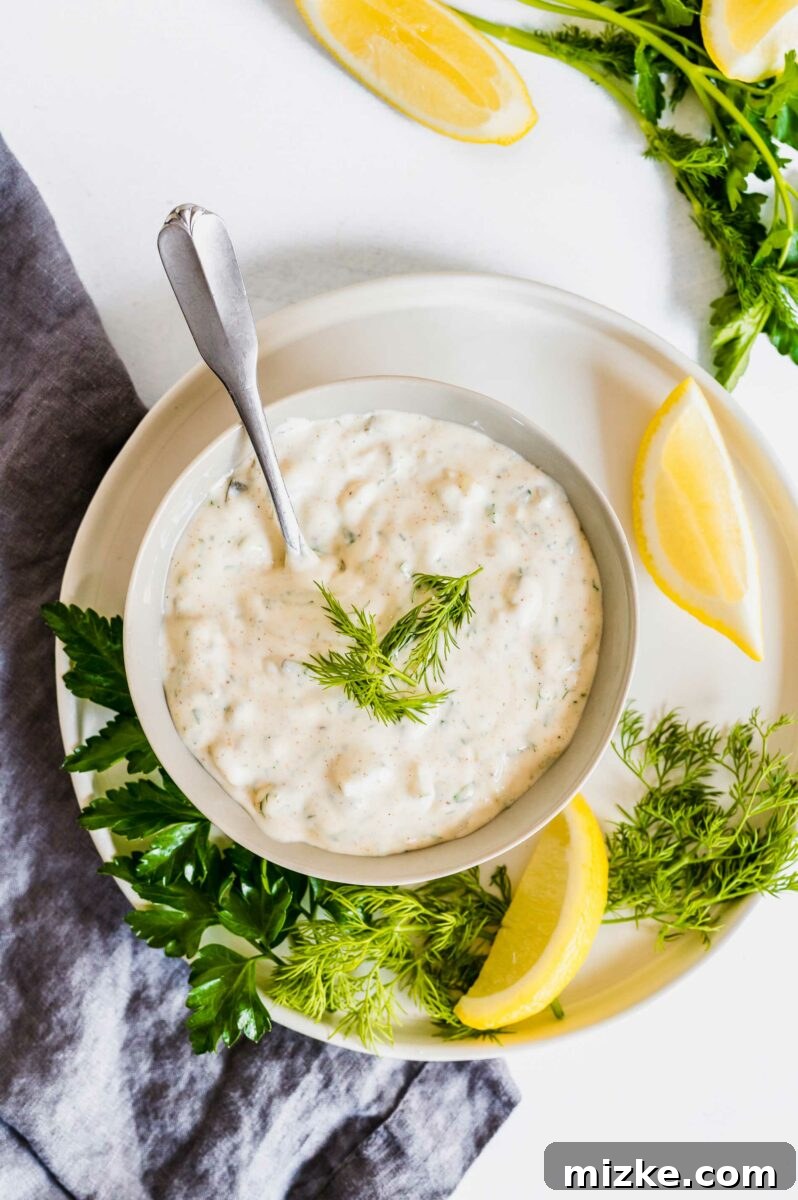 Fresh and Zesty Tartar From Scratch 4 A serving of homemade tartar sauce, elegantly presented on a pristine white plate, garnished and ready to be enjoyed with a meal.