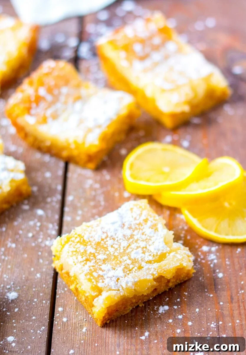 Luscious Lemon Gooey Butter Cake 4 Pieces of buttery lemon cake are sprinkled with powdered sugar.