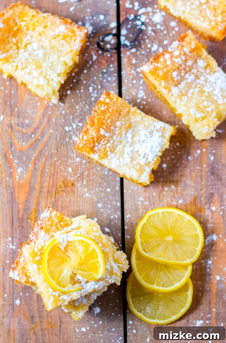 Luscious Lemon Gooey Butter Cake 5 A lemon slice garnishes a square slice of lemon cake.