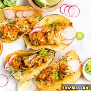 A close-up view of an assembled cauliflower tinga taco, showcasing its rich, smoky filling, fresh slaw, and vibrant garnishes.