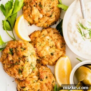 A freshly cooked crab cake is shown up close, exhibiting a golden-brown, crispy exterior and tender, flaky crab meat within, ready to be enjoyed.
