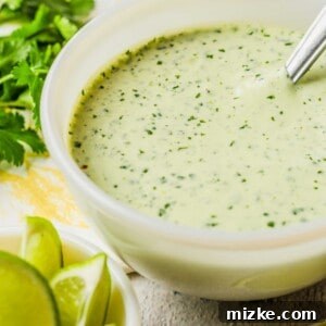 A small white bowl is filled with green dressing. 
