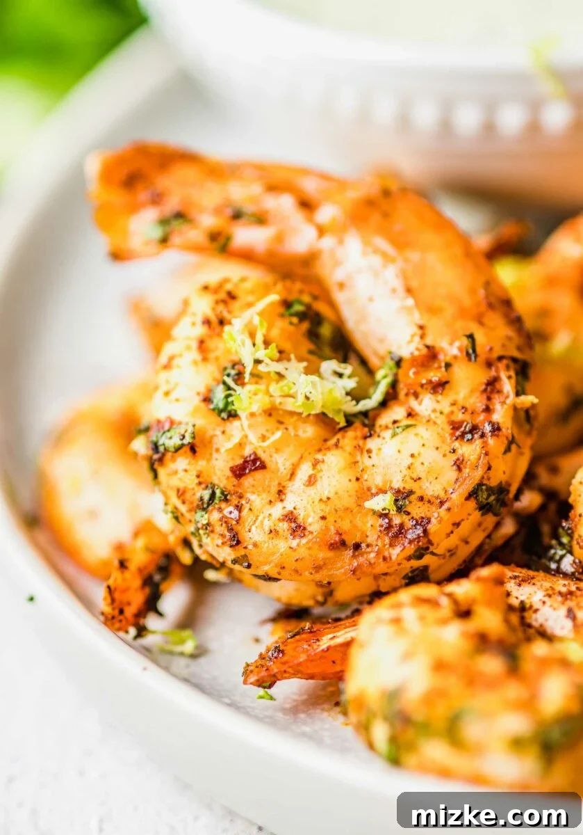 A close-up image shows the details of a single perfectly cooked and seasoned shrimp, highlighting its pink color and inviting texture.
