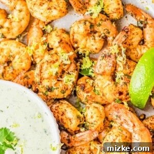 A bowl of freshly cooked spicy cilantro lime shrimp, garnished with fresh cilantro and lime wedges, showcasing their appealing presentation for the recipe card.