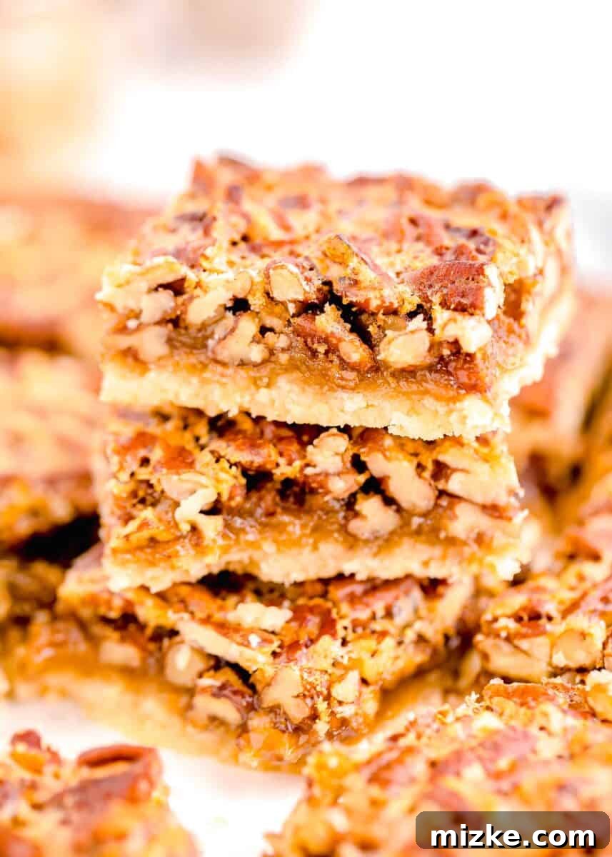 Golden Pecan Pie Squares 13 A stack of three delectable pecan pie bars, sliced open to reveal their enticing layers of chewy pecan filling and crisp shortbread crust.