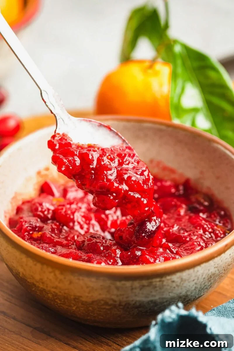 Enjoy this homemade cranberry orange sauce served warm or chilled with your favorite holiday dishes. cranberry orange sauce being spooned from a serving bowl