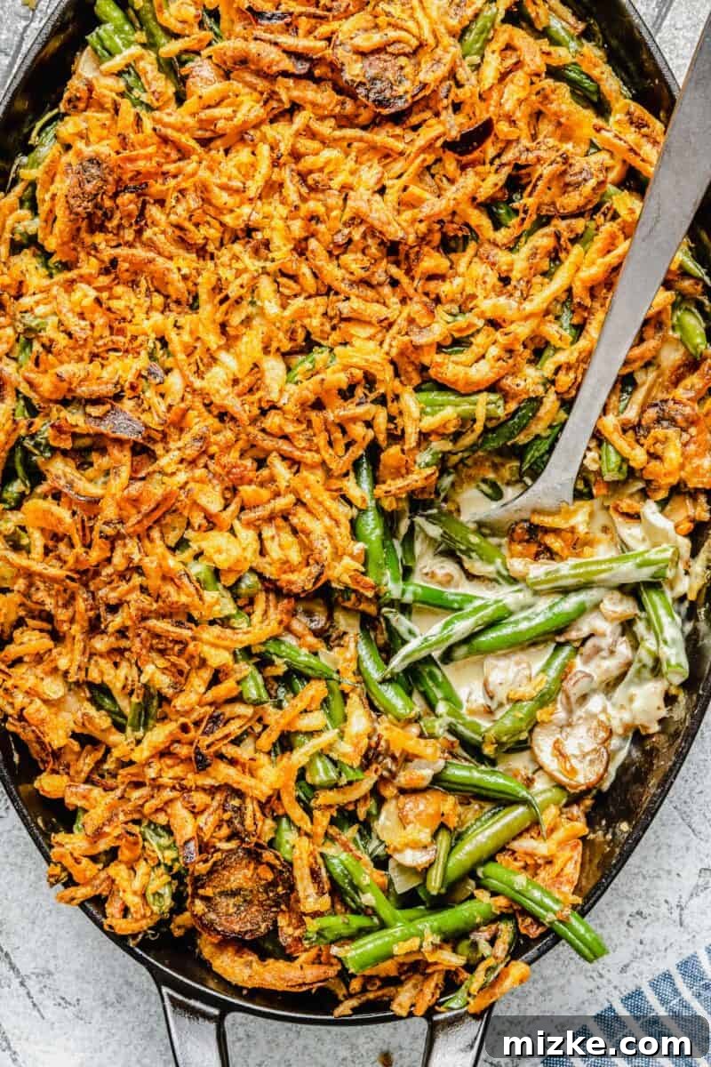 Close-up of the creamy, rich homemade mushroom sauce, studded with sautéed mushrooms and onions, forming the base of the green bean casserole.
