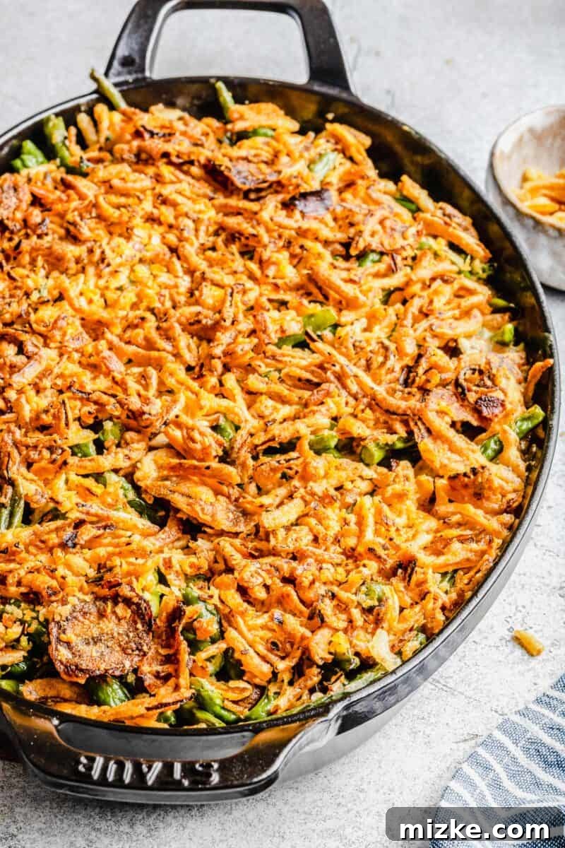 A selection of fresh, high-quality ingredients including vibrant green beans, cremini mushrooms, and yellow onions, meticulously prepared for a homemade green bean casserole.