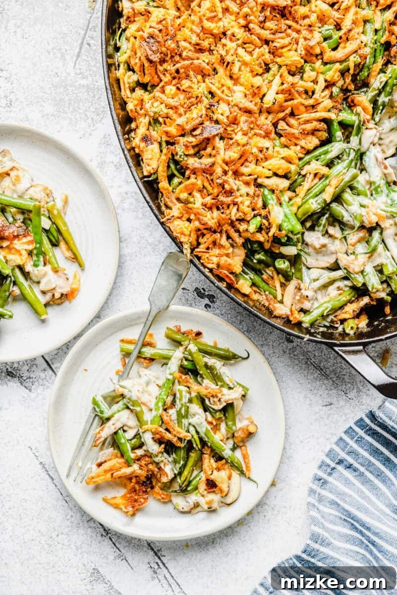 A perfectly portioned slice of homemade green bean casserole, showcasing its creamy interior, tender green beans, and golden crispy fried onion topping.