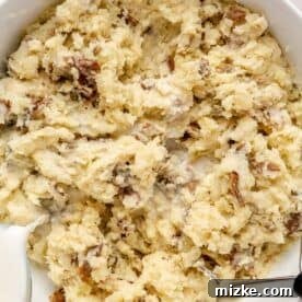 Heavenly Garlic Mashed Potatoes 9 Warm whole milk being slowly poured into a bowl of mashed potatoes, to achieve the perfect creamy texture.