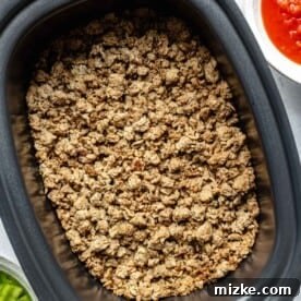 Adding browned meat to a crockpot.