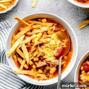 Easy Slow Cooker Chicken Tortilla Soup 8 slow cooker chicken tortilla soup in a white bowl with tortilla strips and melted cheese on top