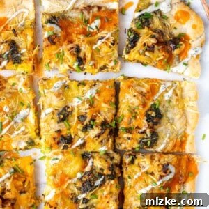 A delicious slice of buffalo cauliflower pizza being served, with additional buffalo sauce drizzled on top.