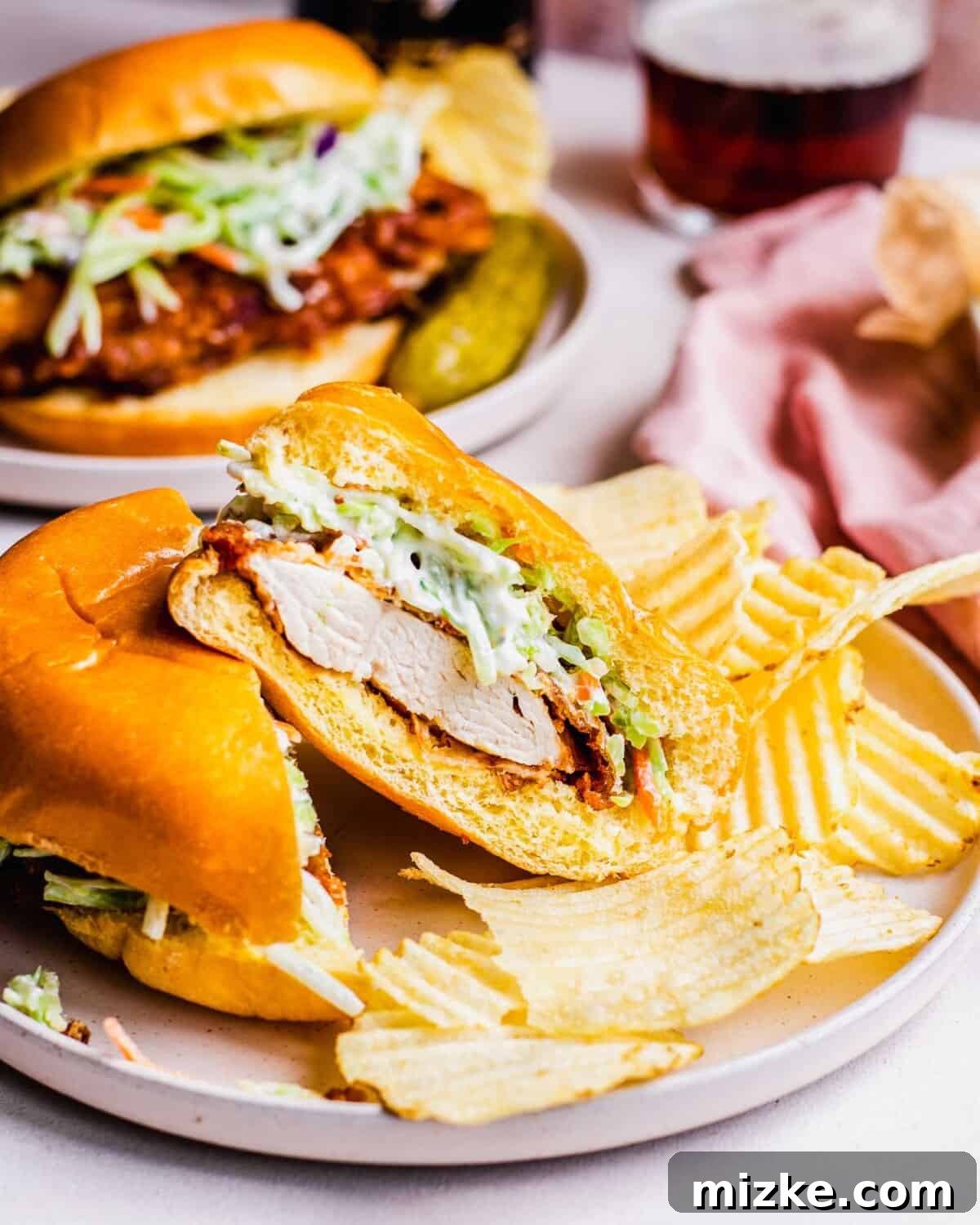 Buttermilk Fried Chicken Sandwich 5 A fried chicken sandwich has been sliced in half, revealing perfectly cooked white meat.