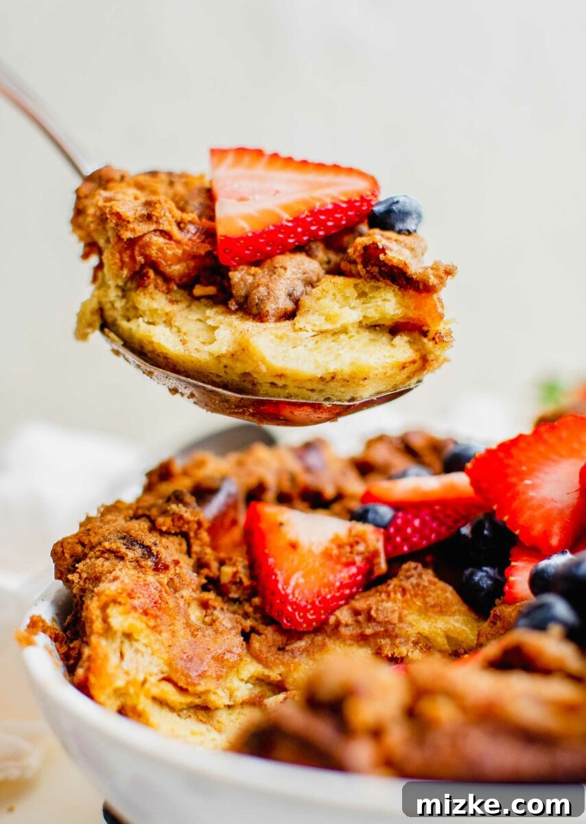 Irresistible Brown Sugar Streusel French Toast Bake 2 A spoon is lifting a bite of casserole from the baking dish.