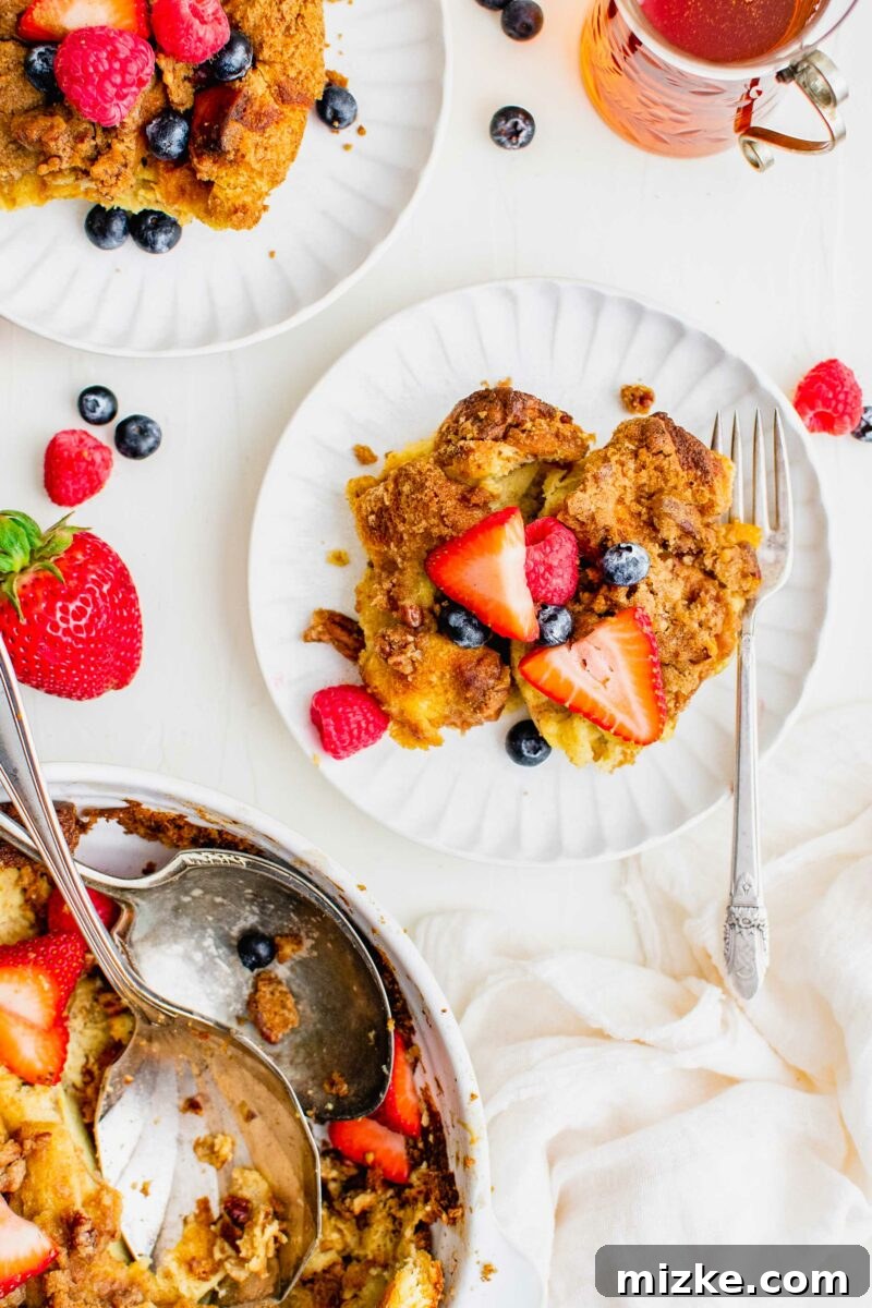 Irresistible Brown Sugar Streusel French Toast Bake 3 A serving of French toast casserole is on a white plate and garnished with berries.