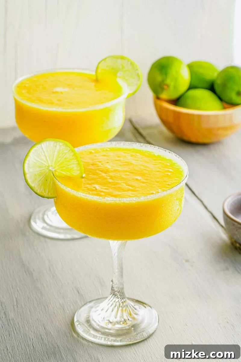 Island Paradise Rum Margarita 3 Limes garnish glasses of frozen margaritas.