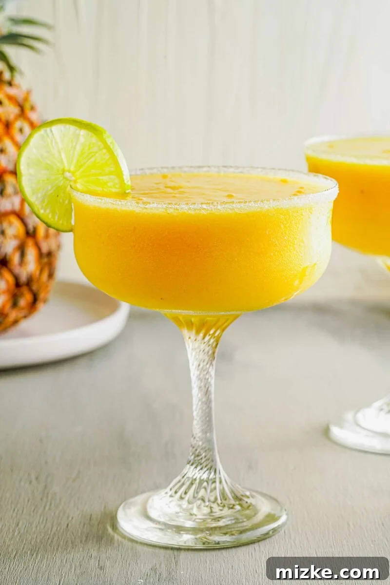 Island Paradise Rum Margarita 5 A pineapple sits behind a full glass.