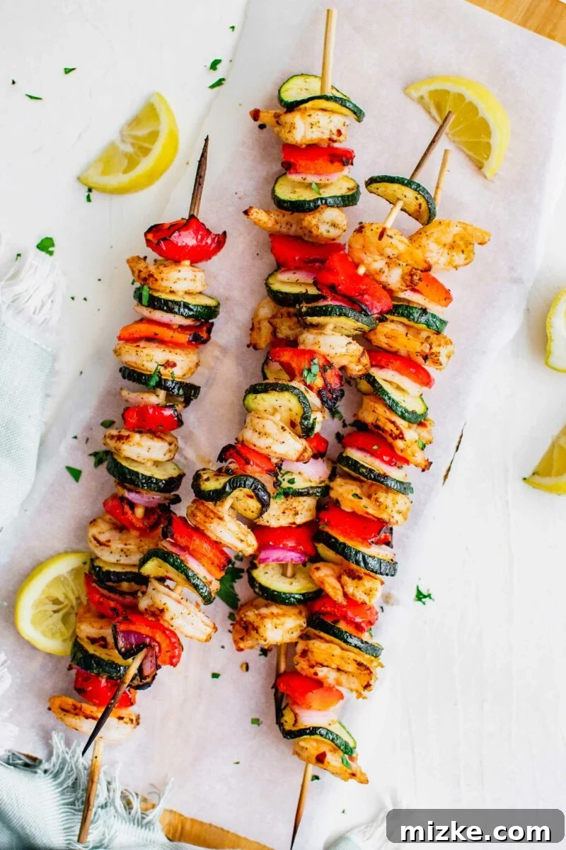 Smoky Grilled Shrimp Skewers 4 Lemon slices are placed next to the shrimp kebobs.