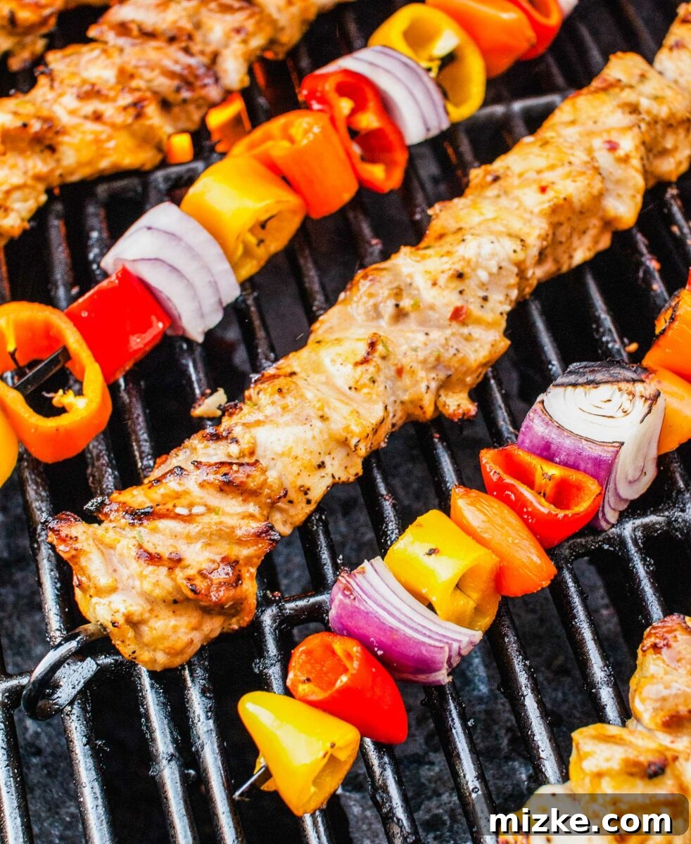 Tropical Coconut Chicken Satay 3 Juicy chicken skewers and colorful veggie skewers sizzling on a hot grill, creating tantalizing char marks.