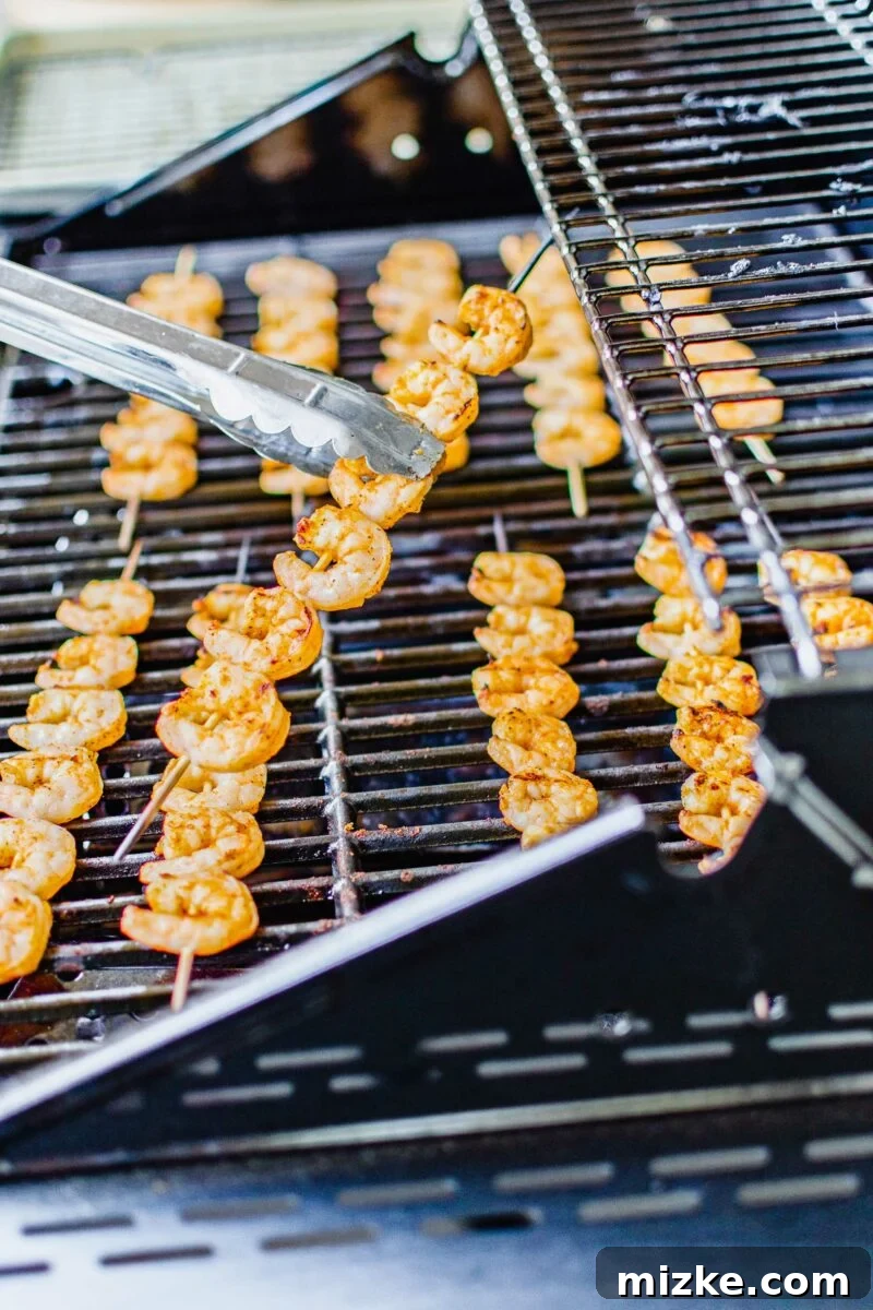 Flame-Kissed Baja Shrimp Skewers 3 A shrimp skewer is being lifted from the grill.