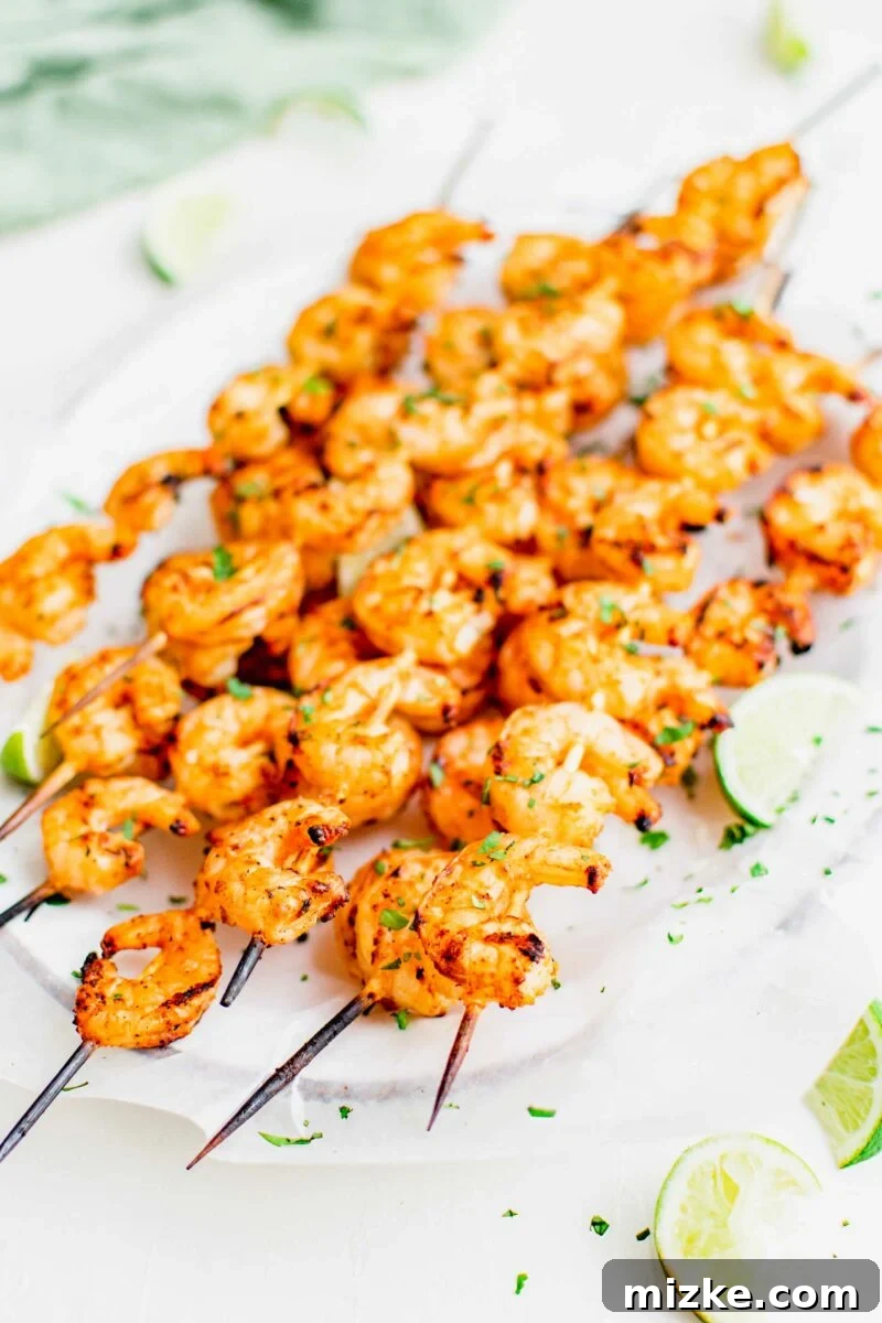 Flame-Kissed Baja Shrimp Skewers 5 Shrimp skewers are garnished with cilantro and lime slices.