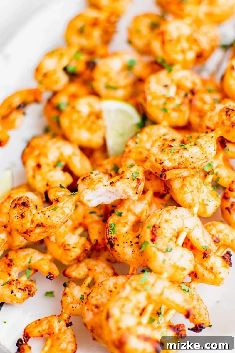 Flame-Kissed Baja Shrimp Skewers 6 A bite of shrimp has been taken, revealing a cooked through white center.