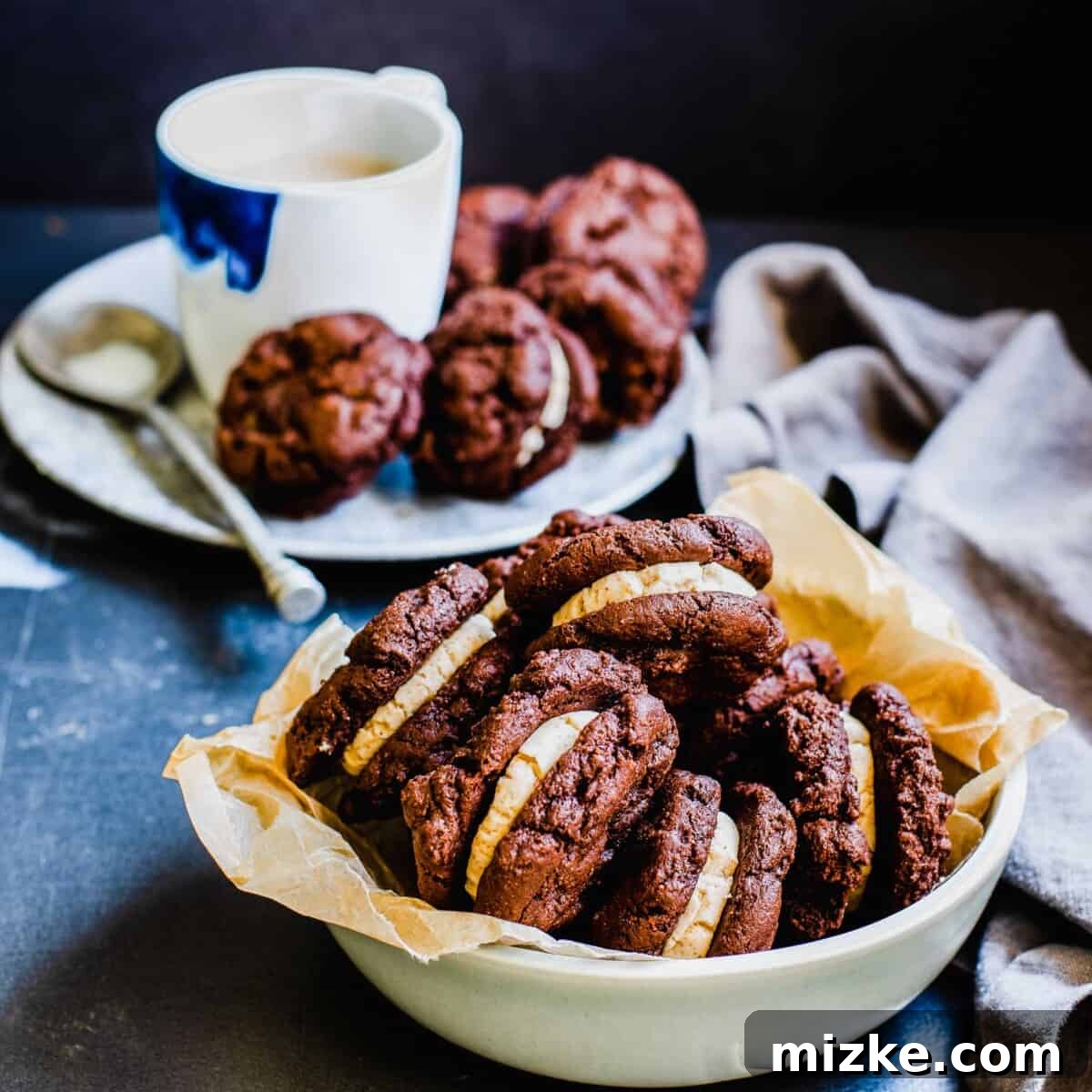 Frozen Mocha Latte Cookie Sandwiches 6 A large bowl overflows with an abundance of mocha latte ice cream sandwich cookies, with more delectable treats artfully arranged on an adjacent plate, inviting everyone to partake.