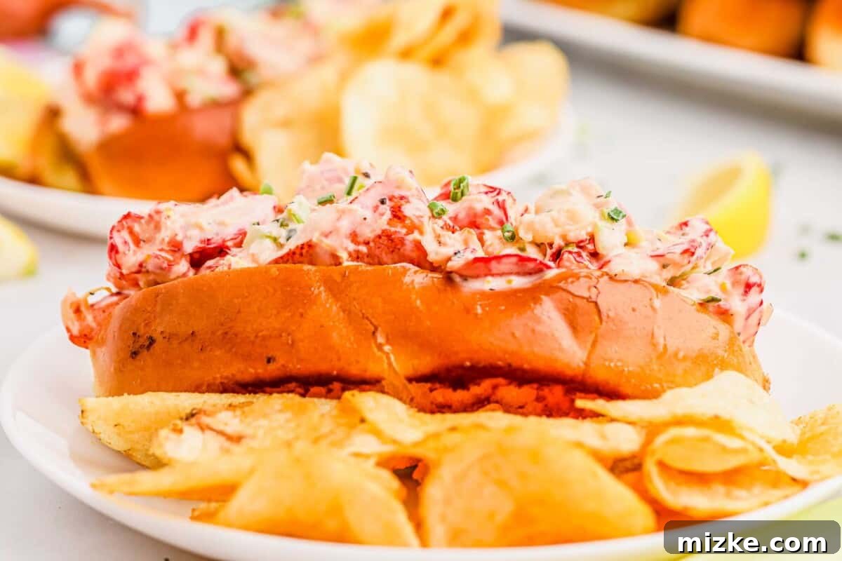 Heavenly Lobster Rolls 9 A side of crispy potato chips accompanies a perfectly golden lobster roll on a clean white plate, ready for a delightful meal.