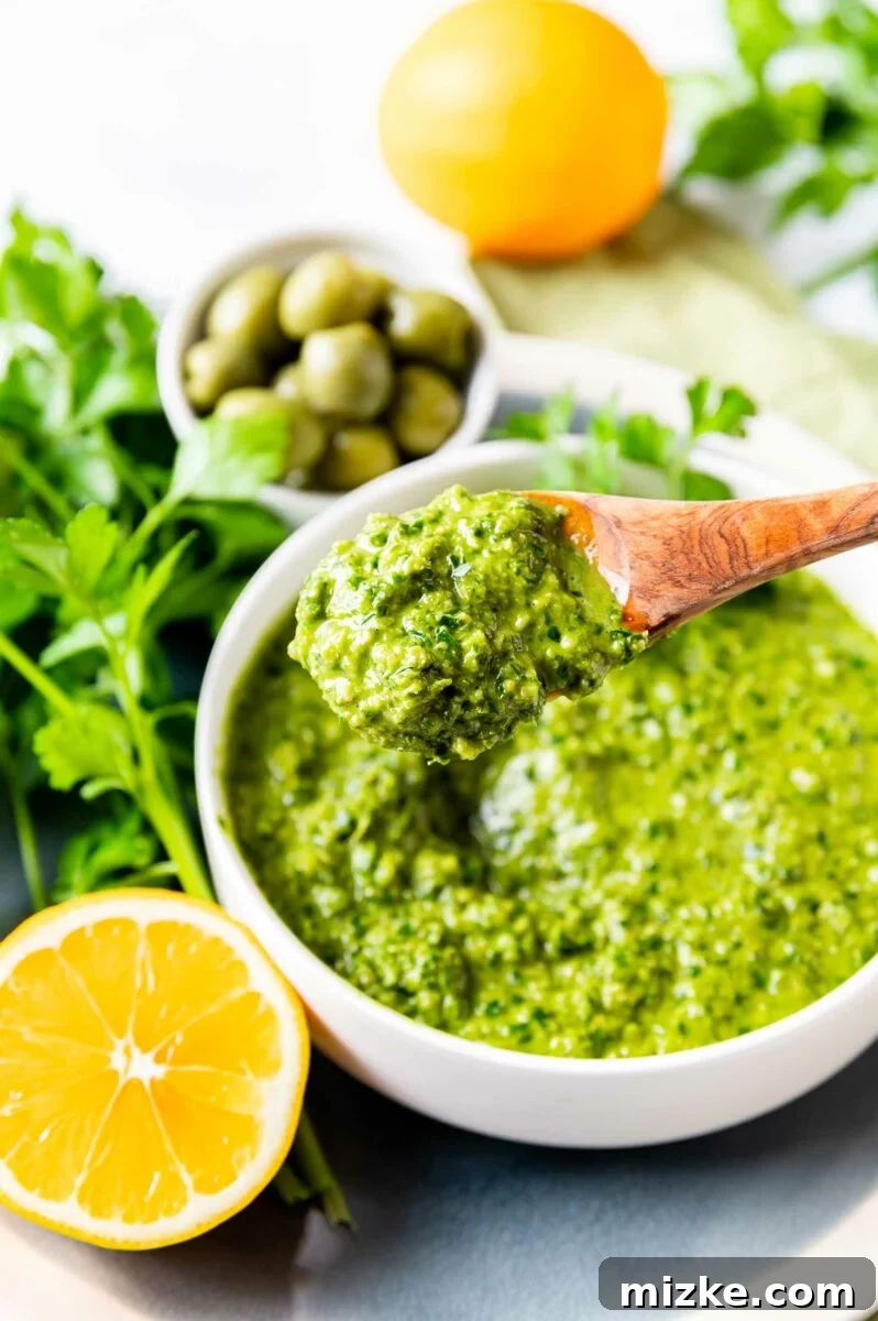 Vibrant Meyer Lemon Green Olive Gremolata 4 A wooden spoon is lifting a portion of the green condiment.