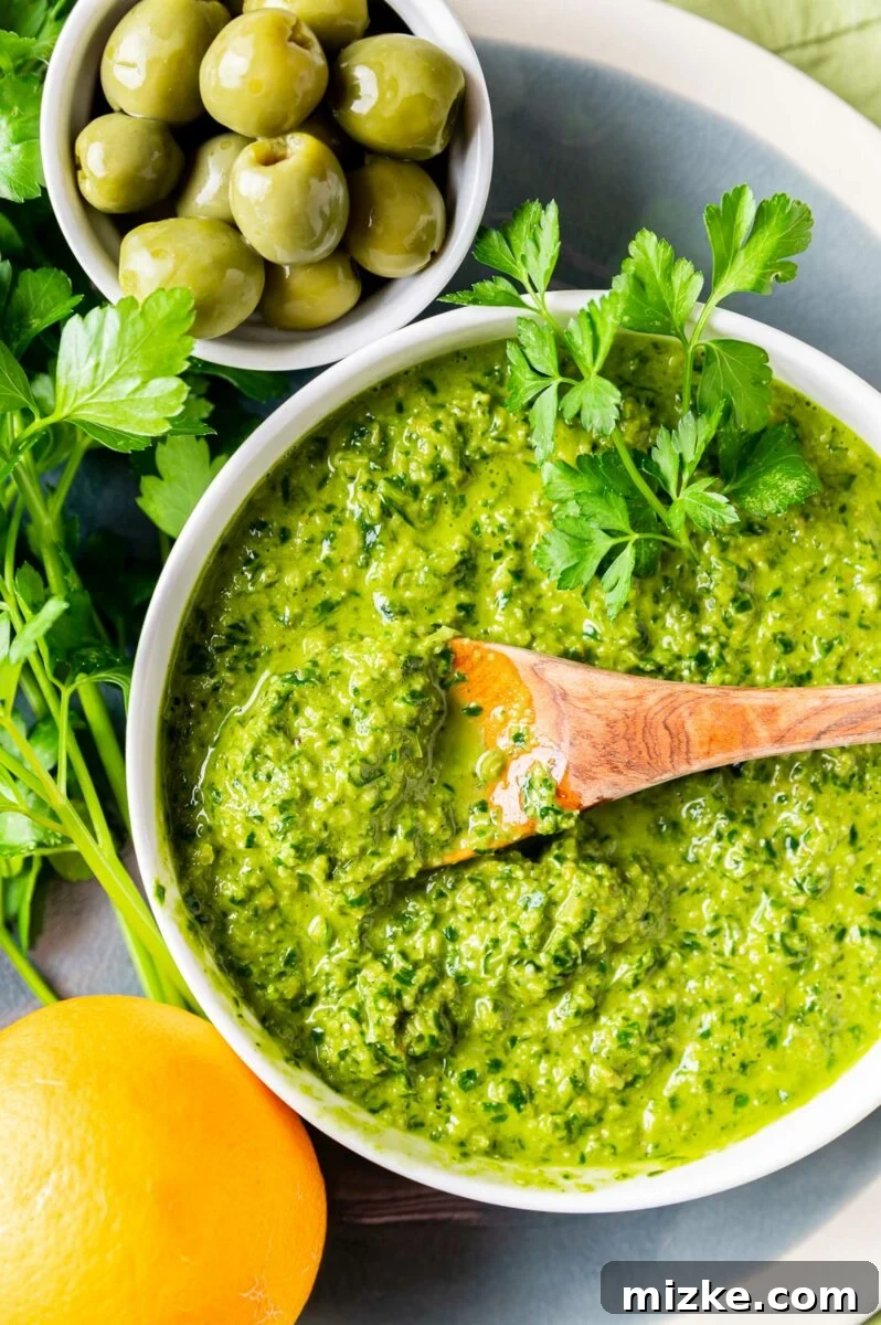 Vibrant Meyer Lemon Green Olive Gremolata 6 A wooden spoon is dipped into the bowl of gremolata.