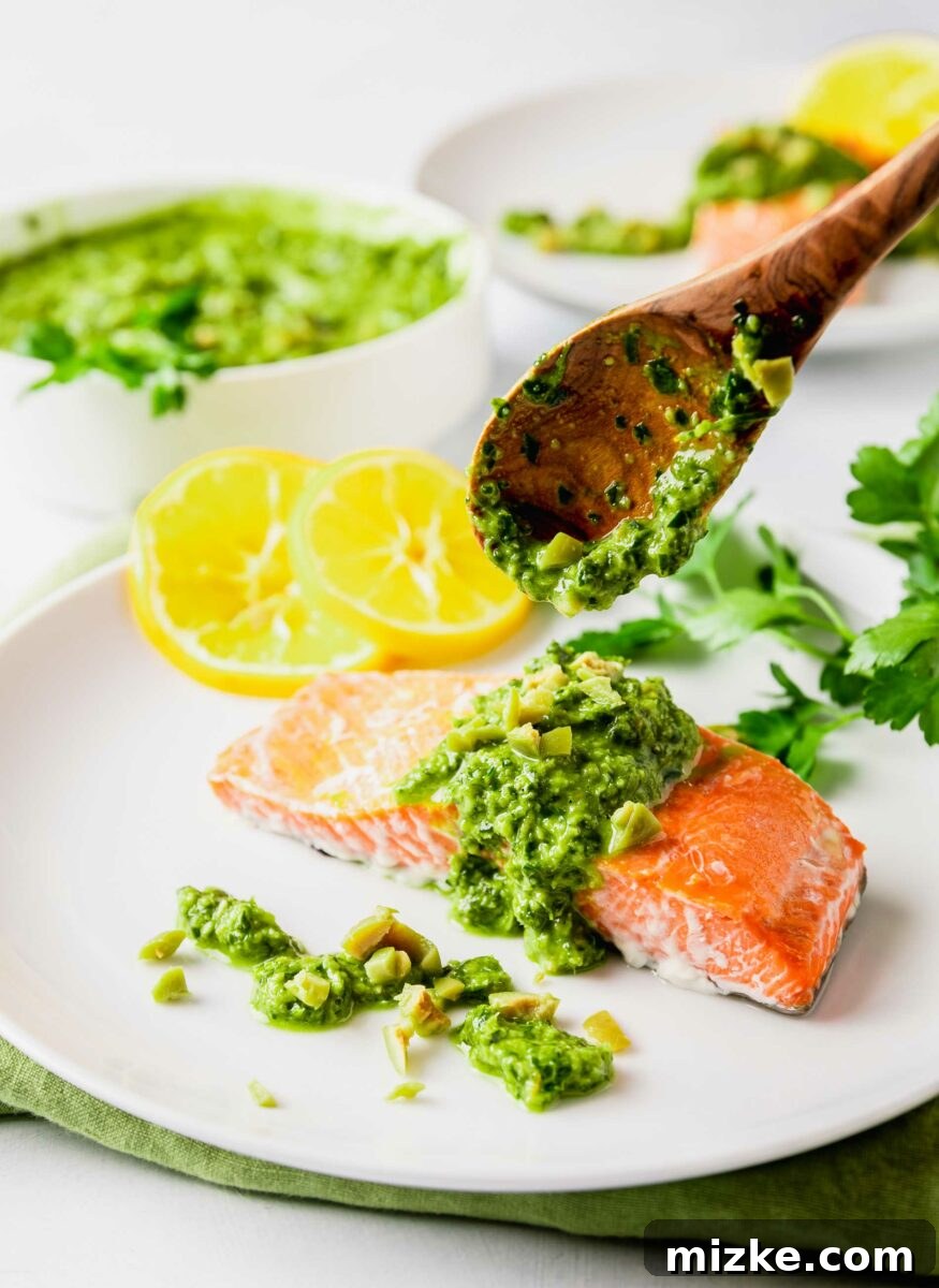 Zesty Green Olive Gremolata Roasted Salmon 4 A wooden spoon is placing gremolata onto a salmon fillet.