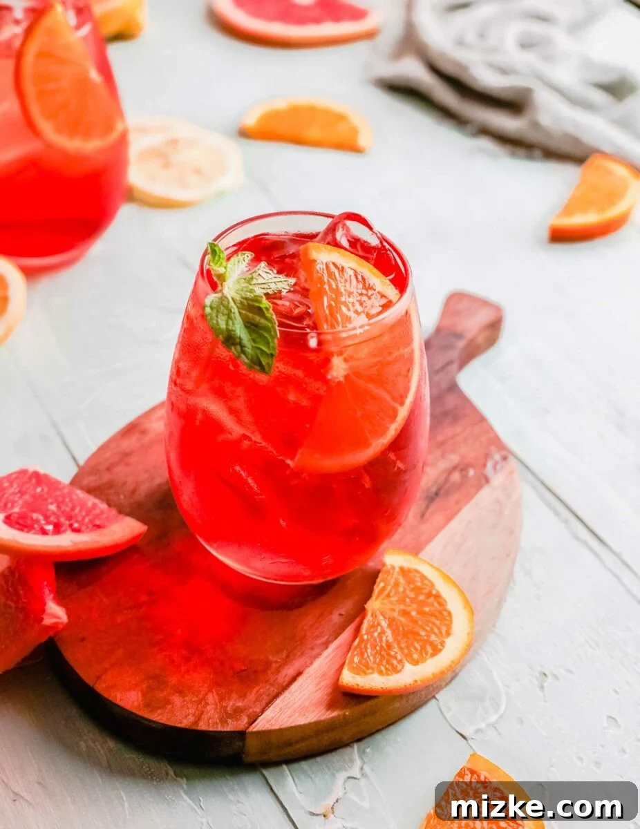 Sunkissed Citrus Sparkler 3 An Aperol Spritz is garnished with a mint leaf and a bright orange slice, ready for enjoyment.